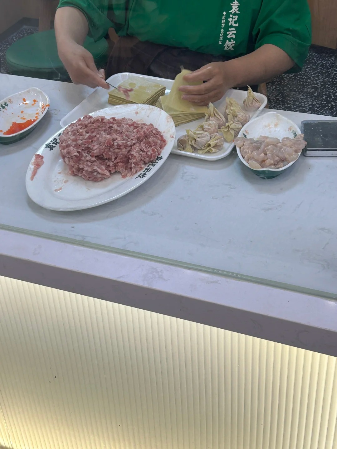 袁记云饺，大妈隔着玻璃包饺子和云吞